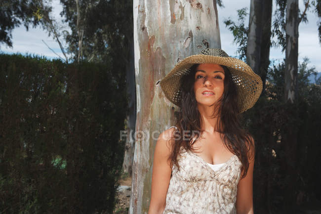 Mujer con sombrero de sol en el bosque - foto de stock