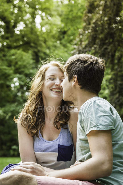 Jeune couple assis dans le parc — Photo de stock