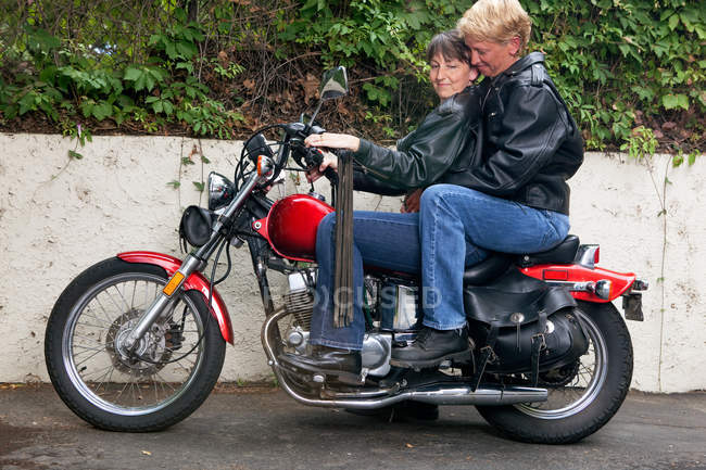 Maduro lesbiana pareja a caballo motocicleta - foto de stock