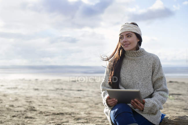 Mujer joven usando tableta digital, Brean Sands, Somerset, Inglaterra - foto de stock