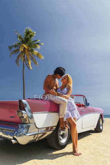 Paar neben Cabrio am Strand — Stockfoto
