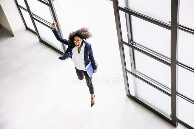 Blick von oben auf Geschäftsfrau, die durch Büroeingang läuft — Stockfoto