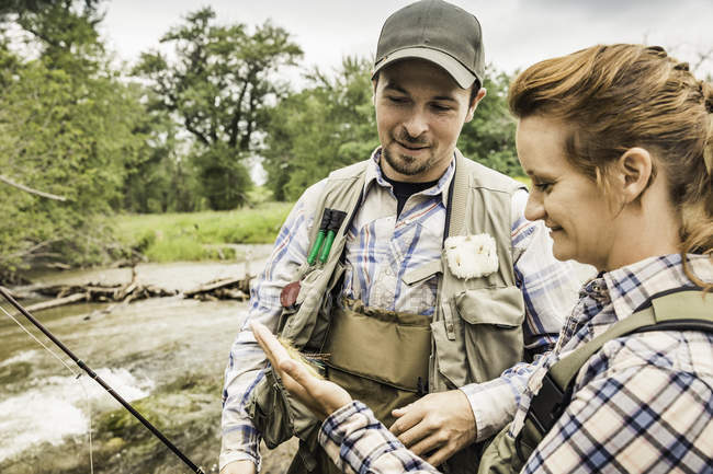 Couple by river preparing for fishing smiling — Stock Photo