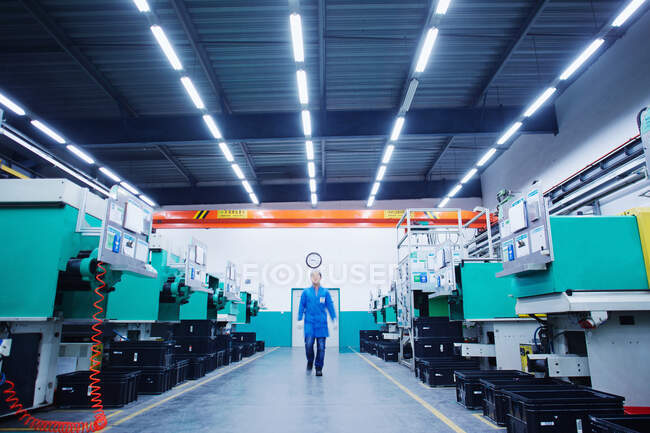 Рабочий, проходящий через завод по производству мелких деталей в Китае — стоковое фото