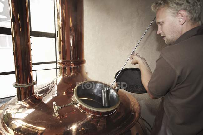 Молодой человек, работающий на пивоварне — стоковое фото