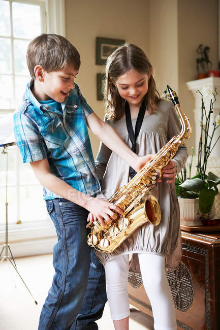 Niños jugando con saxofón - foto de stock