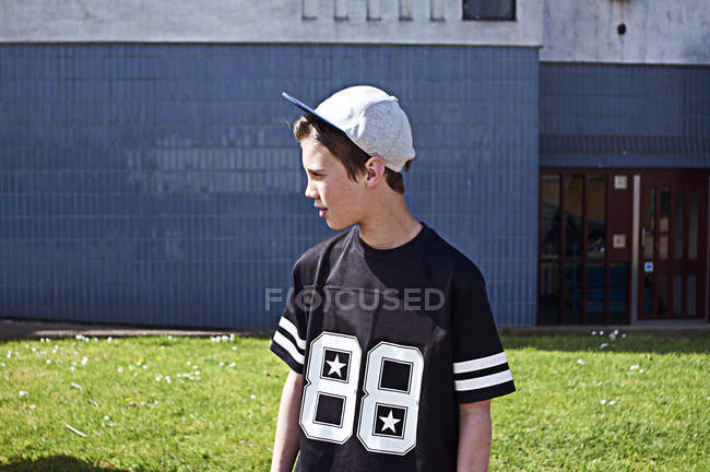 Retrato de menino usando boné de beisebol olhando para longe — Fotografia de Stock