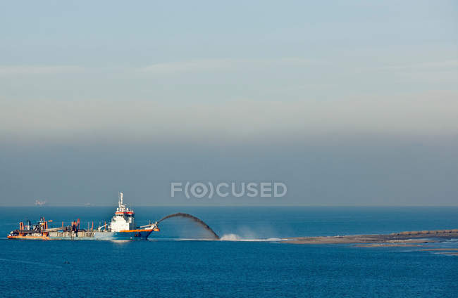 Industrial barge creating new land — Stock Photo