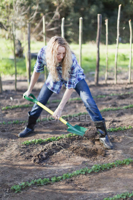 Frau schaufelt Dreck in Garten — Stockfoto
