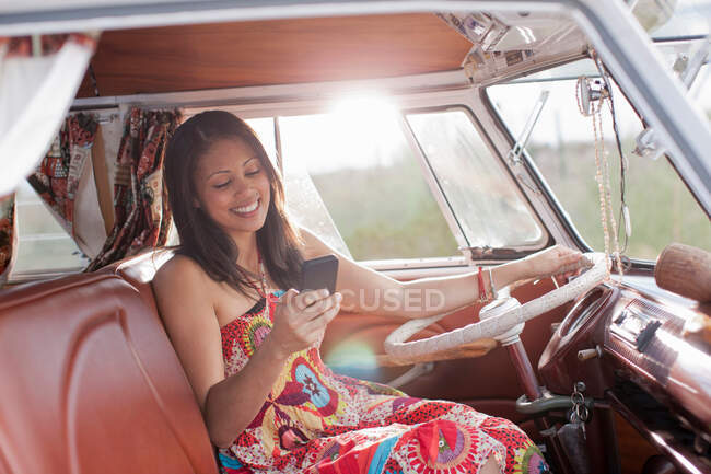 Молода жінка використовує мобільний телефон у фургоні — стокове фото