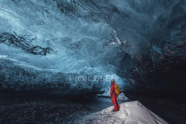 Человек смотрит в ледяную пещеру, ледник Ватнайокалл, Национальный парк Ватнайокалл, Исландия — стоковое фото