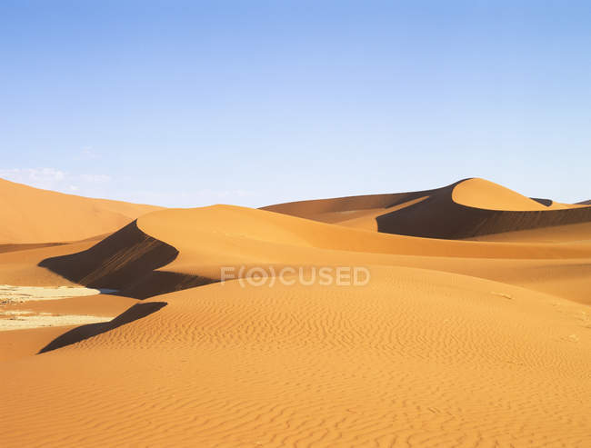 Rippled sand dunes of namib desert under blue sky — Stock Photo