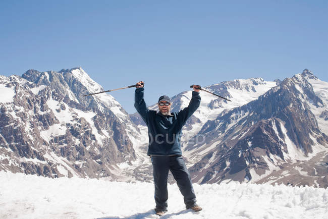 Hiker cheering on snowy mountaintop — Stock Photo