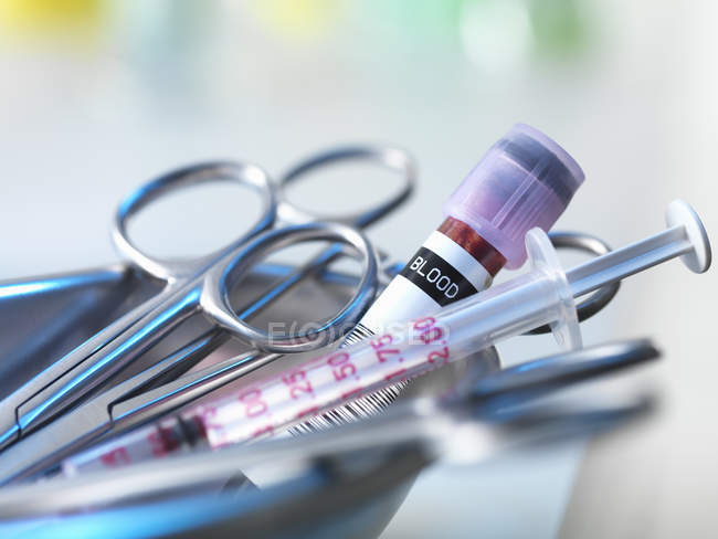 Tesoura, seringa e amostra de sangue em bandeja de metal — Fotografia de Stock