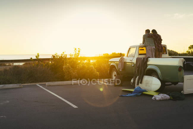 Заднього виду пара в задній пікап дивитися захід сонця в Ньюпорт Біч, штат Каліфорнія, США — стокове фото