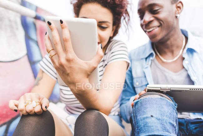 Couple using digital tablets smiling — Stock Photo