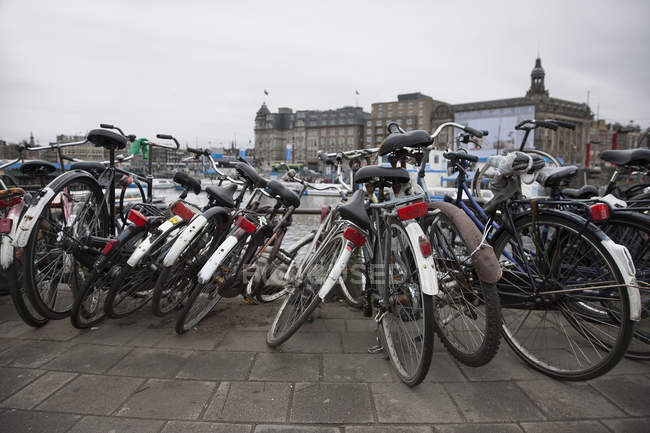 File di biciclette parcheggiate su strada con cielo nuvoloso — Foto stock