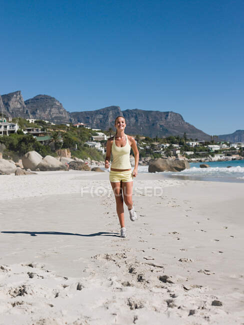 Giovane donna che corre sulla spiaggia — Foto stock