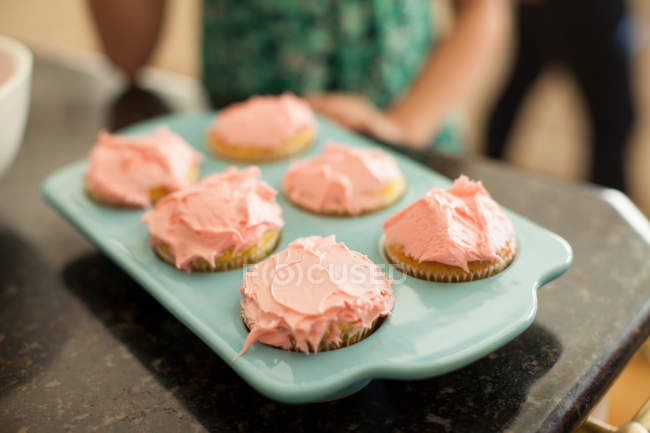 Plaque de cuisson avec six cupcakes glacés, vue rapprochée — Photo de stock