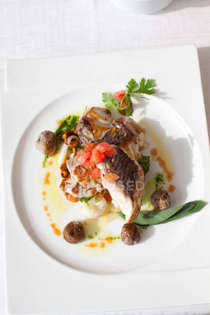 Plate of fish on restaurant table — Stock Photo