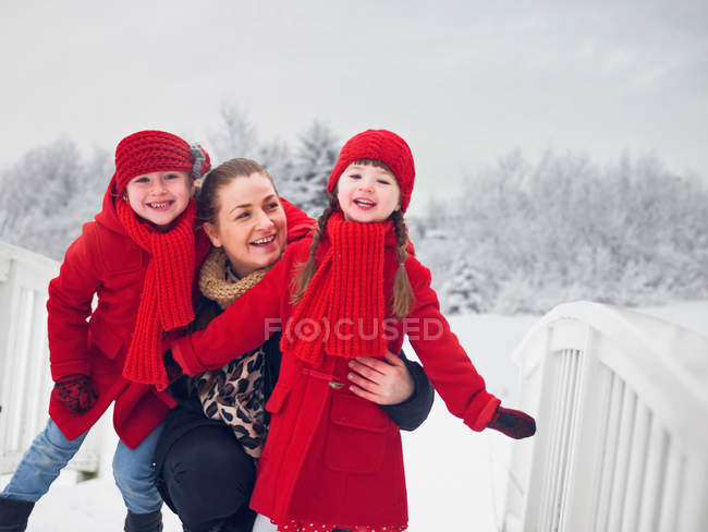 Мать и дочери играют на снегу — стоковое фото