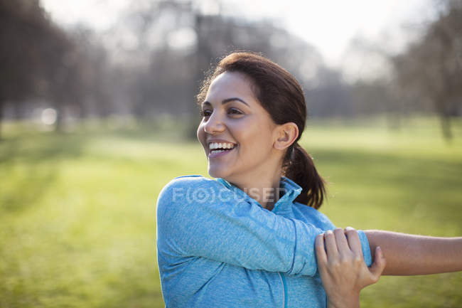 Портрет молодої жінки, що розігріває тренування в парку — стокове фото