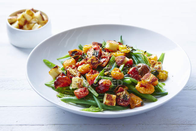 Still life of roast tomatoes and green beans salad — Stock Photo