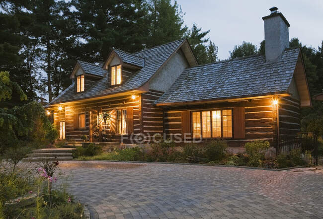 Reconstructed 1976 cottage style log home facade at dusk, Quebec, Canada — Stock Photo
