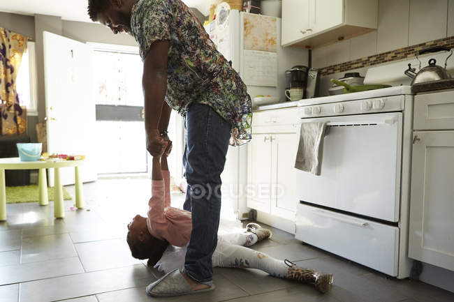 Отец и дочь играют на кухне — стоковое фото