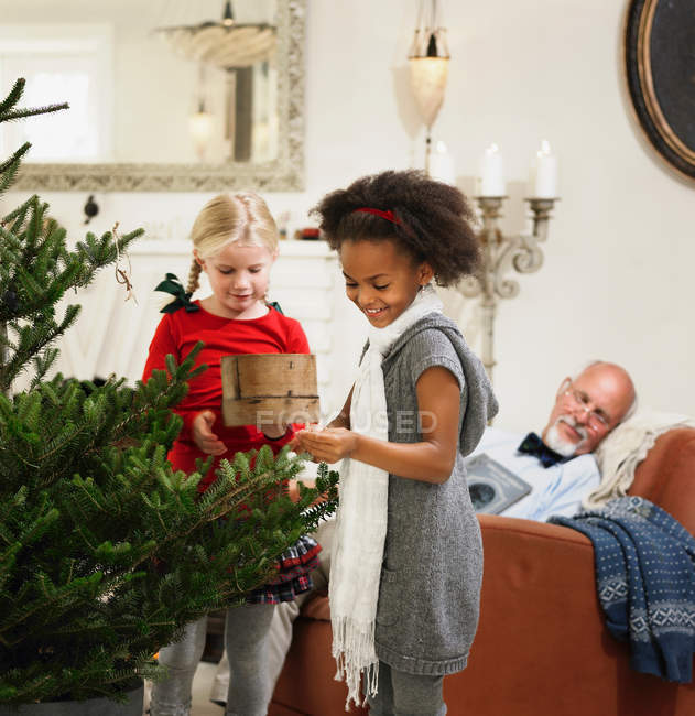 Girls decorating Christmas tree — Stock Photo