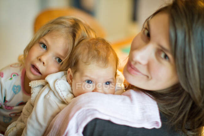 Frau lächelt mit Töchtern — Stockfoto