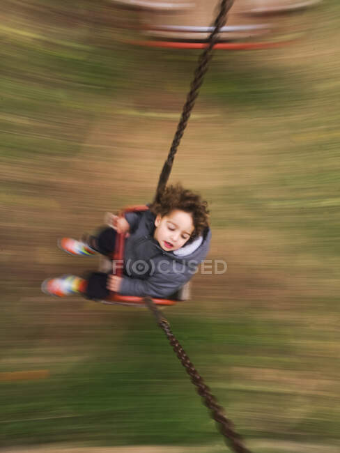 Image floue du garçon sur swing — Photo de stock