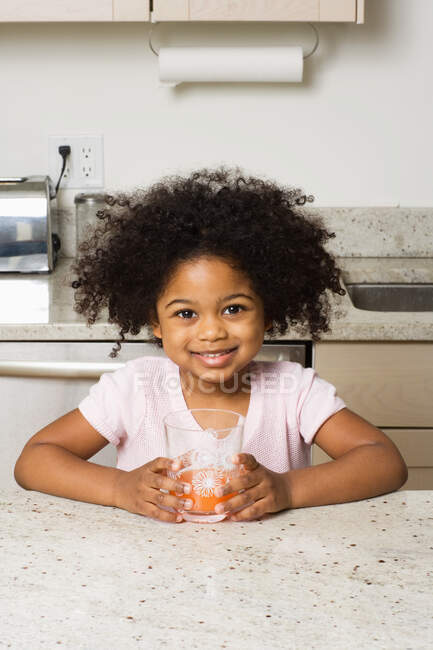 Retrato de una niña sosteniendo un vaso - foto de stock