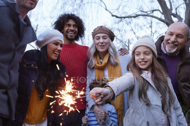 Menina com multi geração família segurando sparkler sorrindo — Fotografia de Stock