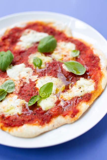 Primer plano de pizza con hierbas y queso mozzarella - foto de stock