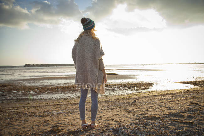 Mujer joven contemplando la playa de Bournemouth, Dorset, Reino Unido - foto de stock