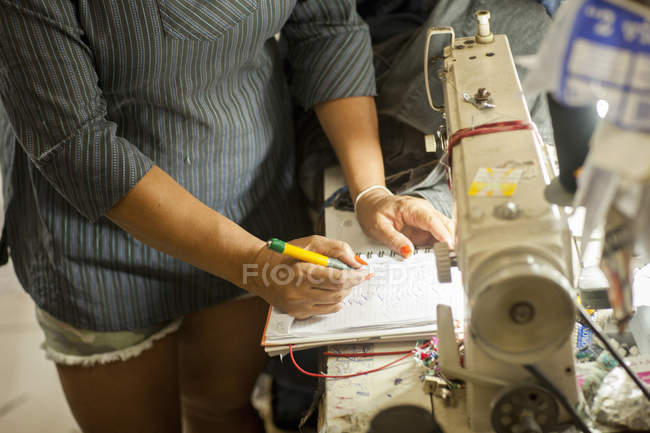 Plan recadré de couturières prenant des notes dans un atelier de couture — Photo de stock