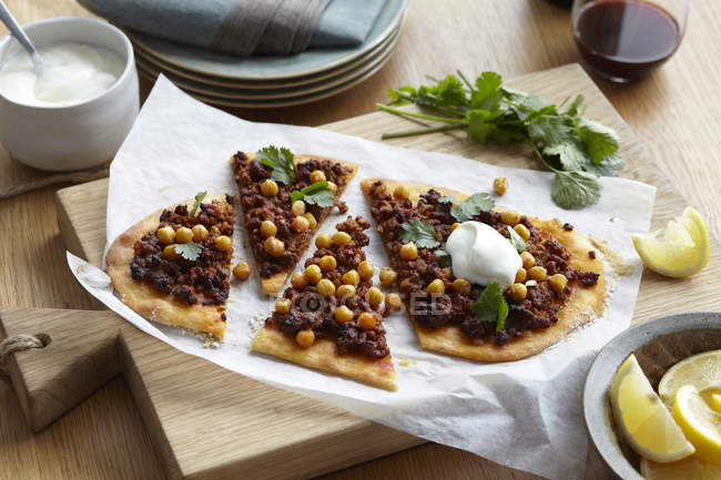 Nahöstliche Lamm- und Kichererbsenpizza mit Kräutergarnitur und Zitronenscheiben — Stockfoto