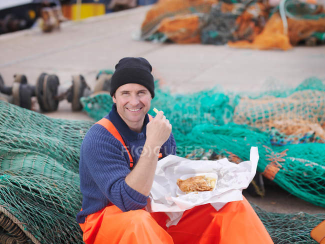 Рыбак ест рыбу и чипсы — стоковое фото