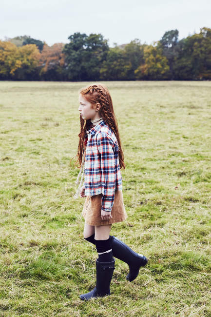 Молодая девушка, идя по полю — стоковое фото