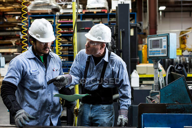 Працівники розмовляють на металургійному заводі — стокове фото