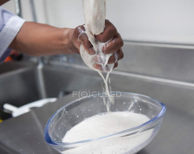 Vista ravvicinata della donna che strizza il latte di mandorla dalla garza — Foto stock