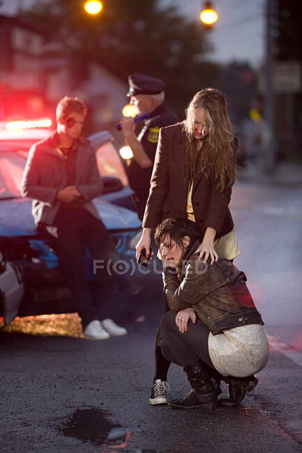 Jovens e policial no local do acidente de carro — Fotografia de Stock