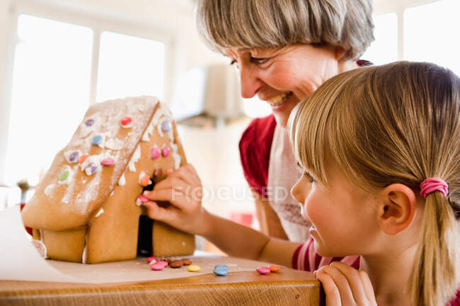 Grandma and grandchild baking cake — Stock Photo