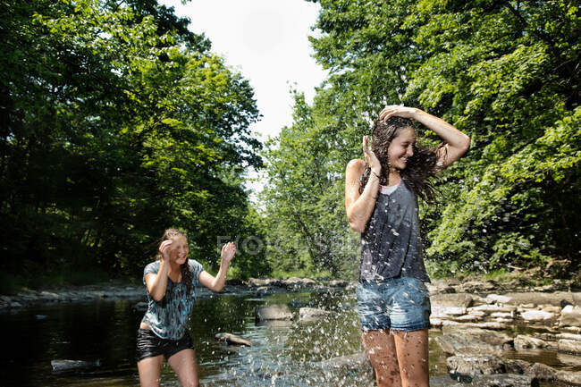 Teenage girls playing in river — Stock Photo