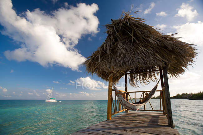 Mujer en hamaca en bungalow tropical - foto de stock