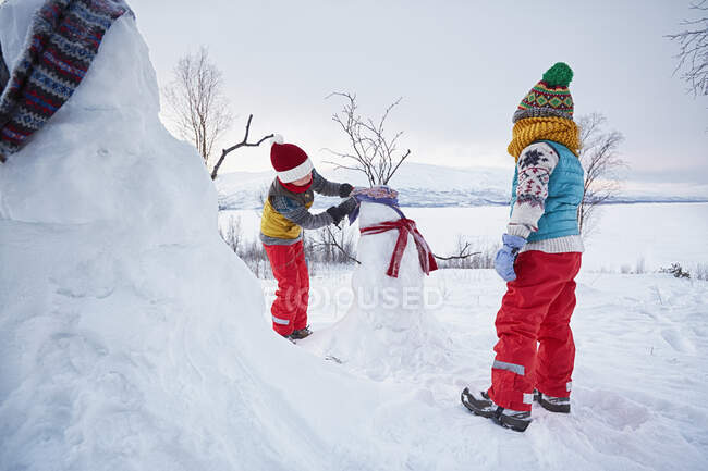 Dos chicos haciendo muñecos de nieve, Hemavan, Suecia - foto de stock