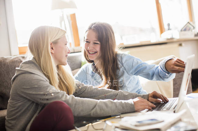 Две девочки-подростка используют ноутбук дома — стоковое фото