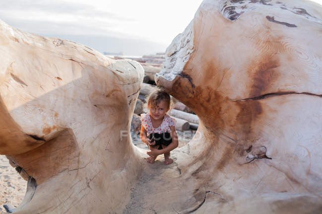 Kleines Mädchen versteckt sich in Holzskulpturen am Strand, Vancouver, Britisch Columbia, Kanada — Stockfoto