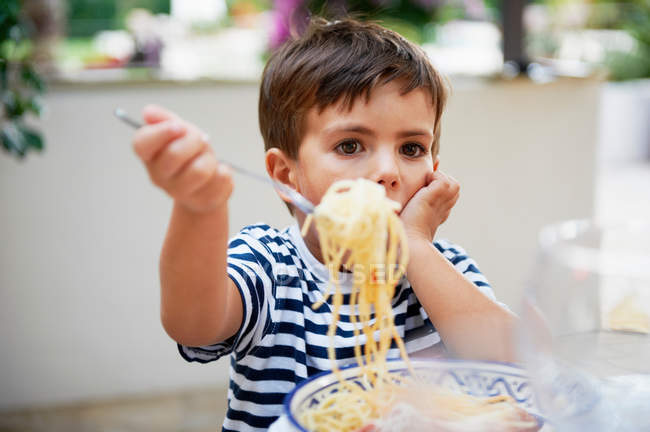 Мальчик ест спагетти — стоковое фото
